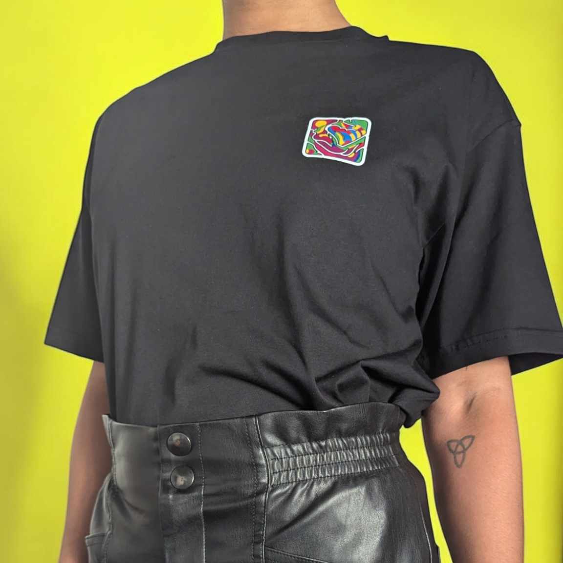 T-shirt unisexe Feelnchill en coton bio noir avec logo festif, coupe oversize et vibes inclusives.